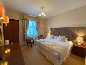 a hotel room with a large bed and a table at Bedford Hotel in Lytham St Annes