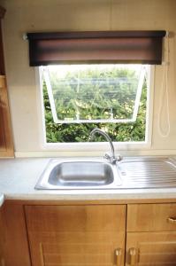 a sink in a kitchen with a window at Świerkowy Zakątek in Orzysz