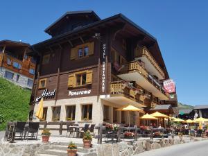 een gebouw met tafels en stoelen ervoor bij Panorama Hotel & Restaurant in Bettmeralp