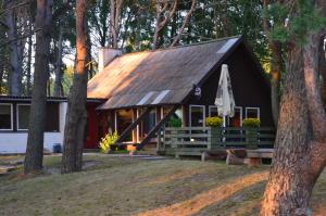une cabine avec un toit en gambrel dans les bois dans l'établissement Rannakodu, à Kabli