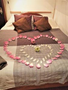uma cama com um coração feito de rosas rosas em La Maison des Bambous Siem Reap em Siem Reap