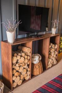 a wooden entertainment center with a television and logs at Angler's Lodge in Island Park