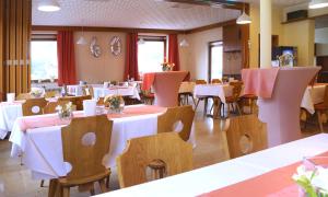 een restaurant met tafels en stoelen met wit tafelkleed bij Hotel Andrea in Crailsheim