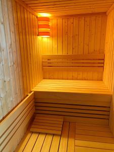 een houten sauna met een bank erin bij Amber Blue Wellness & SPA in Karwia