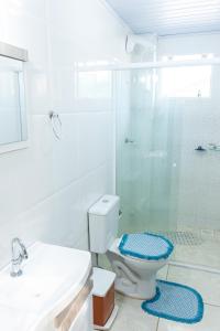 y baño blanco con ducha y aseo. en Apto2 COM AR COND WI-FI E TV SMART en Itapema