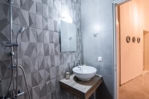 uma casa de banho com um lavatório e um chuveiro em Christi Iuxury Apartment em Preveza
