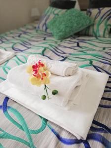 a pair of towels and flowers on a bed at Riviéra Lipno 510/17 in Lipno nad Vltavou