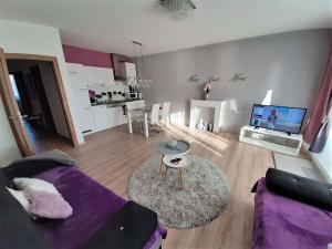 a living room with a purple couch and a table at Riviéra Lipno 510/17 in Lipno nad Vltavou