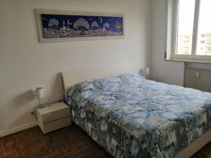 um quarto com uma cama e uma fotografia na parede em CASA CONTE em Pordenone