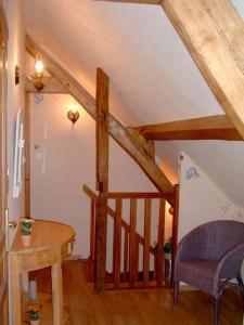 a room with a table and a staircase with wooden beams at la roseraie in Caumont