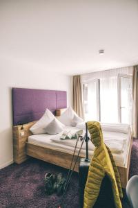 ein Hotelzimmer mit einem Bett und einem Koffer in der Unterkunft Hotel Restaurant Kochschule Rössle in Elzach