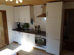 a kitchen with white cabinets and a stove top oven at Ferienwohnung Anna in Inzell