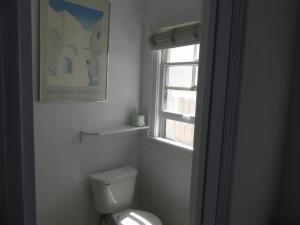 a white toilet sitting next to a window in a bathroom at Hotel del Flores in Los Angeles