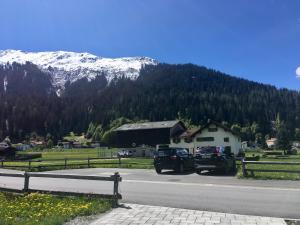zwei LKWs, die an einer Straße mit Bergen geparkt sind in der Unterkunft Ferienwohnung Uf Z`Enisch in Klosters
