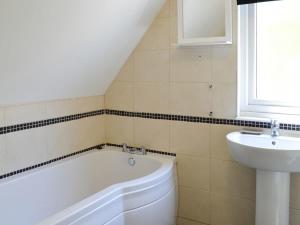 ein Badezimmer mit einer Badewanne und einem Waschbecken in der Unterkunft Cornwall holiday homes in Hayle
