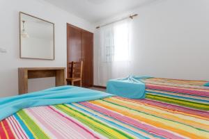 1 dormitorio con 1 cama con una manta colorida en Apartamentos Oliveira, en Madalena