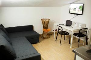 ein Wohnzimmer mit Sofa und einem Tisch mit Laptop in der Unterkunft B&B Kòre in Castellammare del Golfo