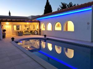 a house with a swimming pool in front of a house at Villa Sunkiss Algarve Carvoeiro in Carvoeiro