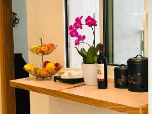 a counter with a bowl of fruit and a bottle of wine at Villa Sunkiss Algarve Carvoeiro in Carvoeiro