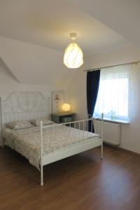1 dormitorio con cama blanca y ventana en Pokoje na Falistej, en Mechelinki