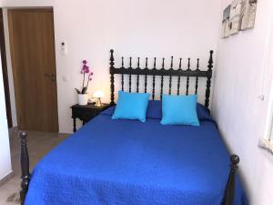 a bedroom with a blue bed with two blue pillows at Villa Sunkiss Algarve Carvoeiro in Carvoeiro