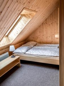 a bedroom with a bed in a wooden attic at U Srubu, Újezd u Boskovic in Újezd