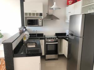 a kitchen with a stainless steel refrigerator and appliances at Apt de frente e com vista Lagoa in Arraial do Cabo