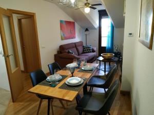 a dining room with a table and chairs and a couch at VEGA-ARANDA in Fresnillo de las Dueñas