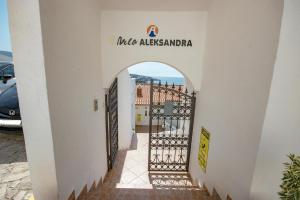 een poort naar een gebouw met een bord waarop Casias argentina staat bij Studio Apartments Aleksandra in Utjeha