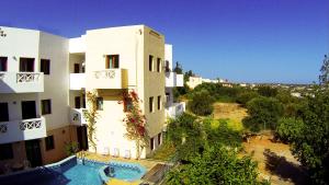 an external view of a building with a swimming pool at Romantica Hotel Apartments by Estia in Hersonissos