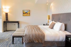 a hotel room with a bed and a bench at Braemar Lodge And Spa in Hanmer Springs