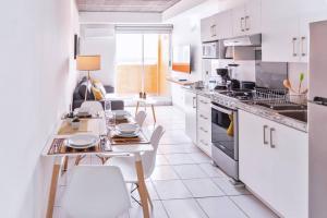 a kitchen with white cabinets and a table and chairs at MONTERREY LIVING Centro T5 in Monterrey