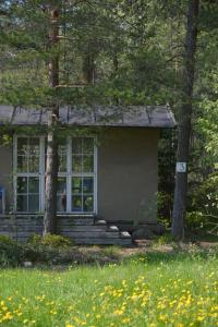 uma pequena casa com uma grande janela e árvores em Sattmark EcoCabin em Pargas