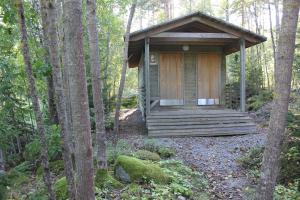 a wooden cabin in the middle of the woods at Sattmark EcoCabin in Pargas +6 photos