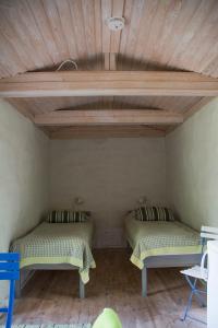 two beds in a room with a wooden ceiling at Sattmark EcoCabin in Pargas