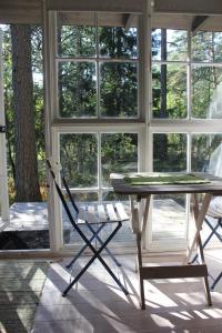 uma mesa e uma cadeira num quarto com janelas em Sattmark EcoCabin em Pargas