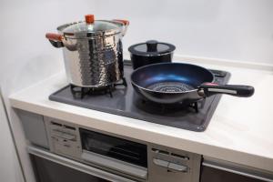a frying pan and a pot on a stove at Convertel Honhaneda by Tranova in Tokyo +34 photos
