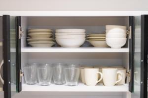 a cabinet filled with plates and cups and bowls at Convertel Honhaneda by Tranova in Tokyo