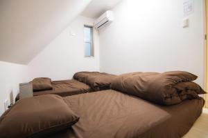 Zimmer mit 3 Betten und einem Fenster in der Unterkunft Convertel Honhaneda in Tokio