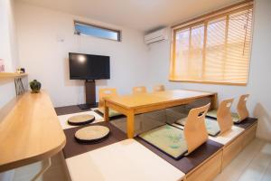 a room with a table and chairs and a tv at Convertel Honhaneda by Tranova in Tokyo