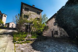 un antiguo edificio de piedra con un banco delante de él en Ostello Podesteria di Gombola - arte e territorio en Polinago