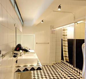 a bathroom with a sink and a black and white tiled floor at 3Howw Hostel Khaosan in Bangkok