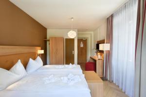 a hotel room with a bed with flowers on it at Waldhotel Unspunnen in Interlaken +39 photos