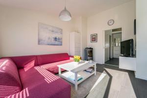 a living room with a purple couch and a table at Three-Bedroom Apartment in Tjørhom