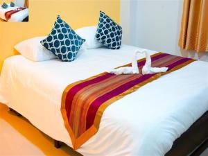 a hotel room with a bed with towels on it at Na Dream Place in Surat Thani
