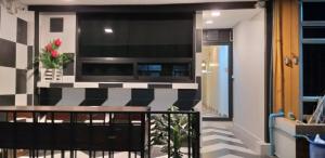 a balcony with a table and a television on a wall at Benjamas hostels in Bangkok