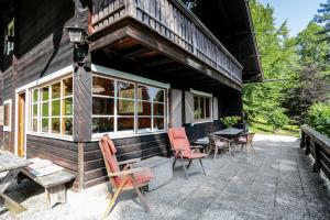 a porch of a house with chairs and tables at Schlierseehaus in Schliersee