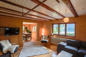 a living room with a couch and a tv at Schlierseehaus in Schliersee