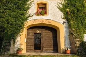 una entrada a un edificio con puerta de madera en Penzion Vinicky dvůr, en Kaplice