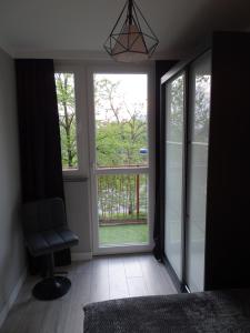 a room with a window with a chair and a window at No71 The Luxury Apartment in Głogów